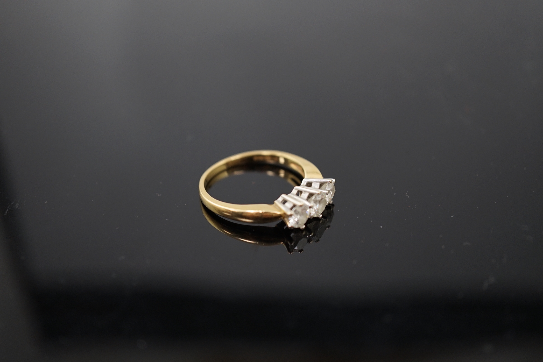 A modern 18ct gold and three stone diamond set ring